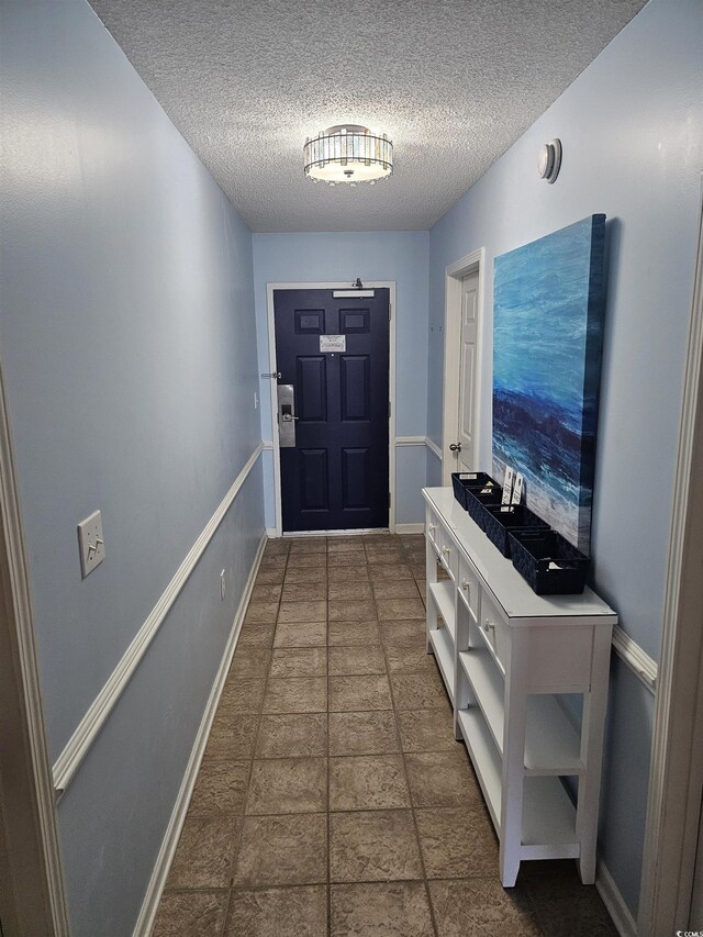 doorway featuring baseboards and a textured ceiling