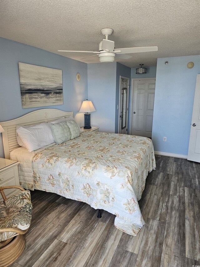 bedroom featuring wood finished floors, a textured ceiling, a ceiling fan, and baseboards