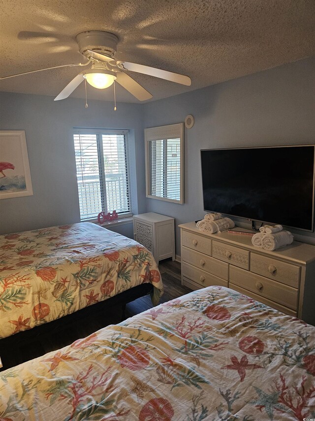 bedroom with dark wood-style flooring, ceiling fan, and a textured ceiling