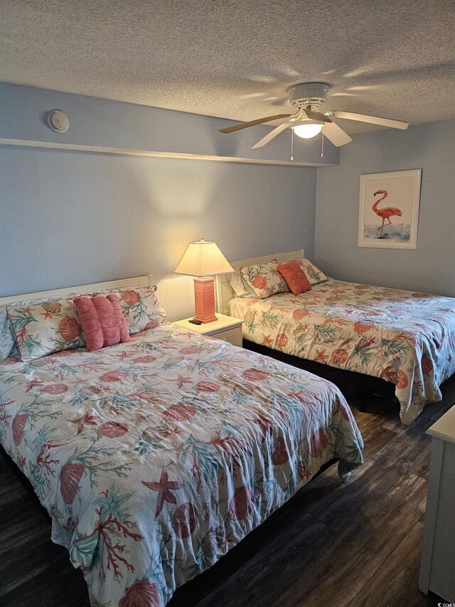 bedroom with wood finished floors, a textured ceiling, and a ceiling fan