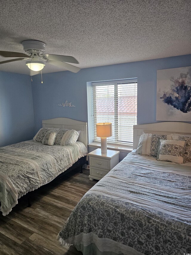 bedroom with a textured ceiling, dark wood finished floors, and a ceiling fan