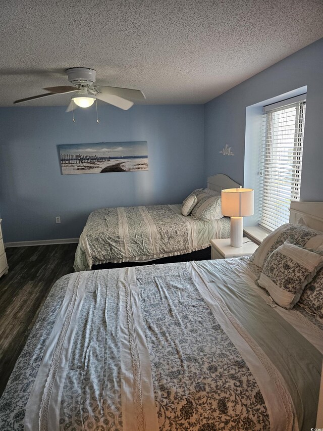 bedroom featuring wood finished floors, a textured ceiling, ceiling fan, and baseboards