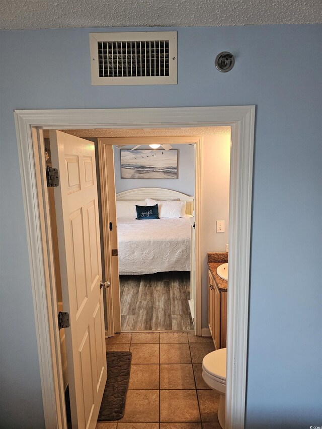 bathroom with vanity, tile patterned floors, toilet, and ensuite bath