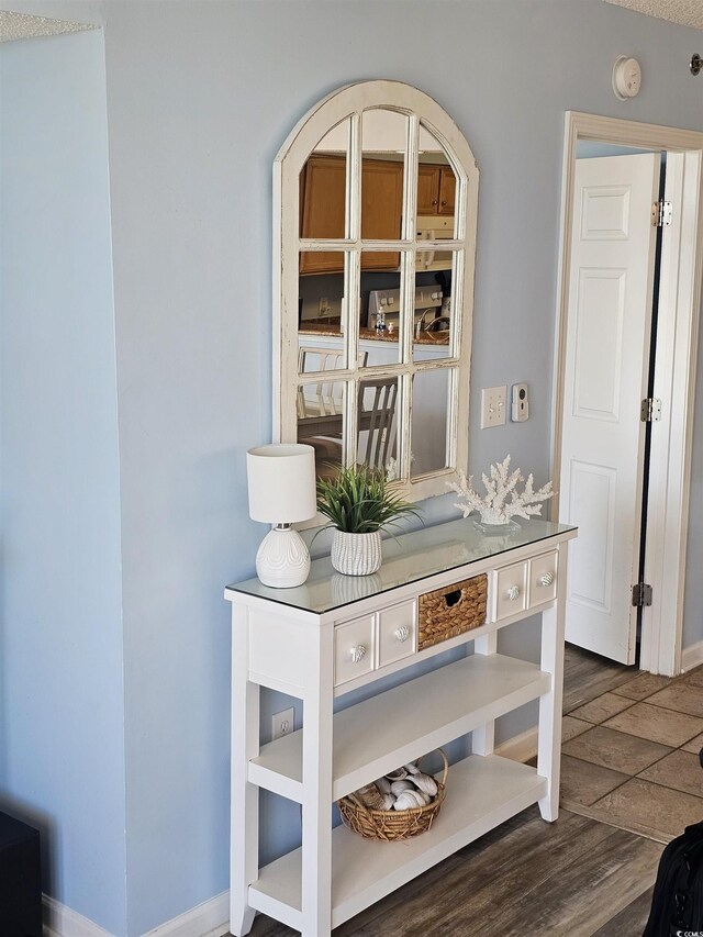 detailed view of wood finished floors, baseboards, and a smoke detector