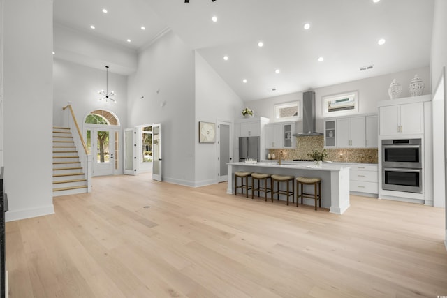 985 Shipmaster Ave, Myrtle Beach, SC 29579 - kitchen featuring a breakfast bar, high vaulted ceiling, wall chimney exhaust hood, stainless steel appliances, and tasteful backsplash