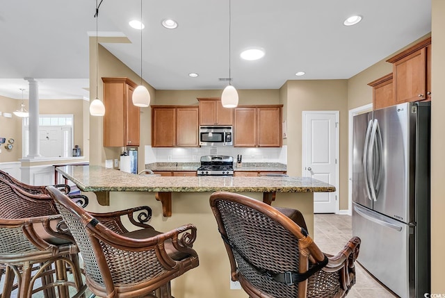 156 Summerlight Dr, Murrells Inlet, SC 29576 - kitchen featuring appliances with stainless steel finishes, decorative columns, backsplash, a breakfast bar, and light stone counters