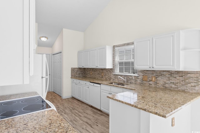 kitchen featuring lofted ceiling, white dishwasher, stove, light wood-type flooring, and a sink