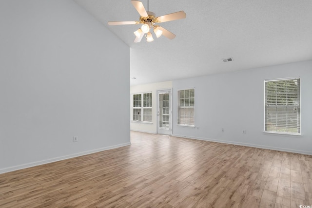 spare room with a ceiling fan, visible vents, baseboards, high vaulted ceiling, and light wood-style floors