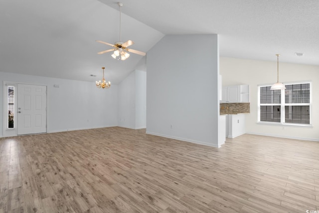 unfurnished living room featuring baseboards, light wood finished floors, ceiling fan with notable chandelier, and high vaulted ceiling