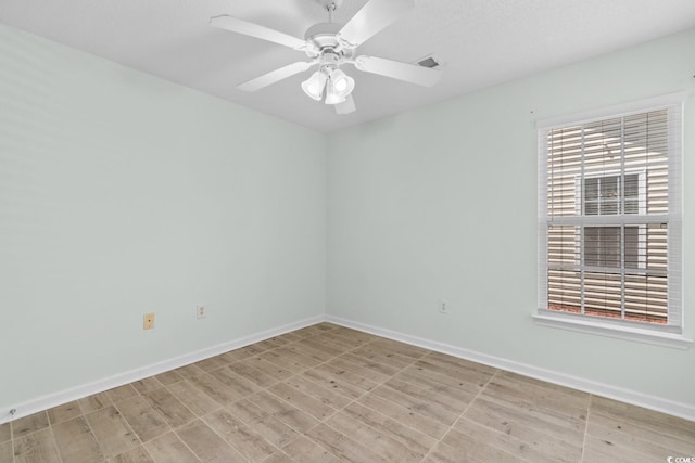 unfurnished room featuring baseboards, light wood-style floors, and ceiling fan