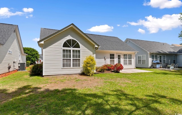 back of property featuring a patio, a shingled roof, a lawn, and cooling unit