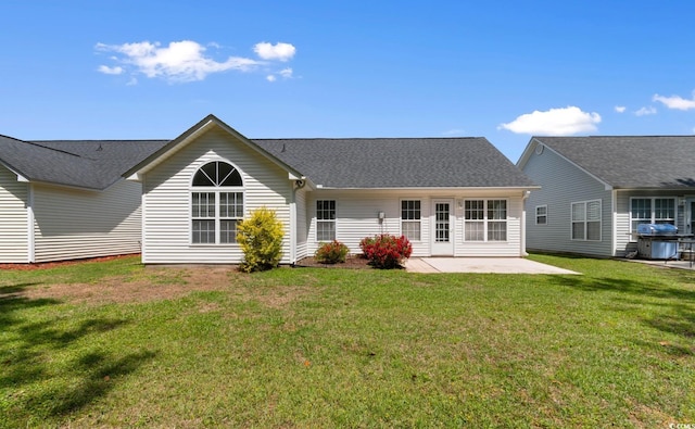 rear view of property with a lawn and a patio