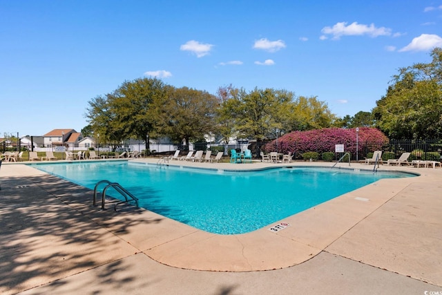 pool with a patio and fence