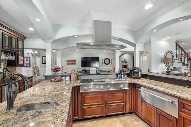 kitchen with a sink, stainless steel gas cooktop, ornate columns, a warming drawer, and light stone countertops