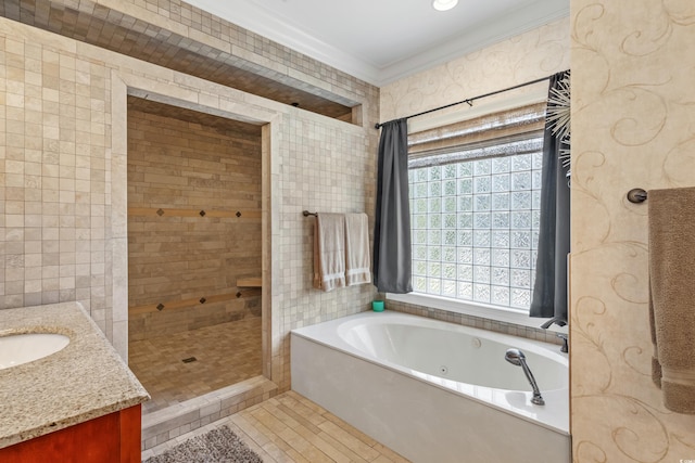 bathroom featuring tile walls, a shower stall, vanity, crown molding, and a tub with jets