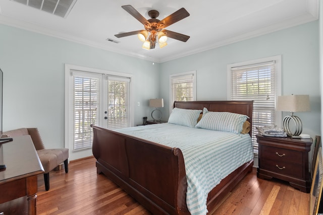 bedroom with multiple windows, ornamental molding, visible vents, and access to exterior