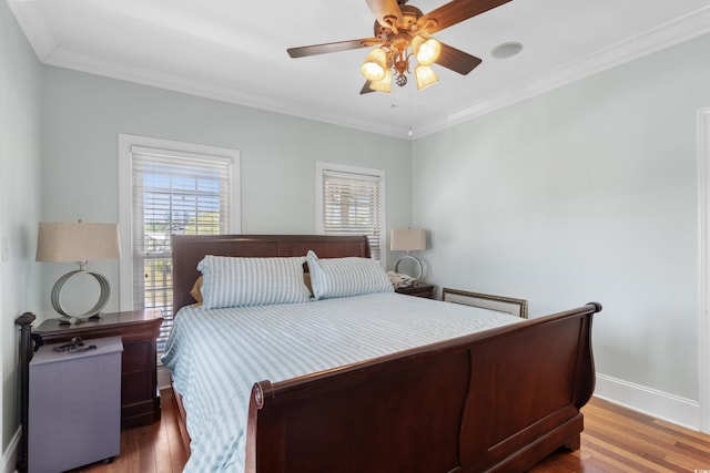 bedroom with baseboards, crown molding, and wood finished floors