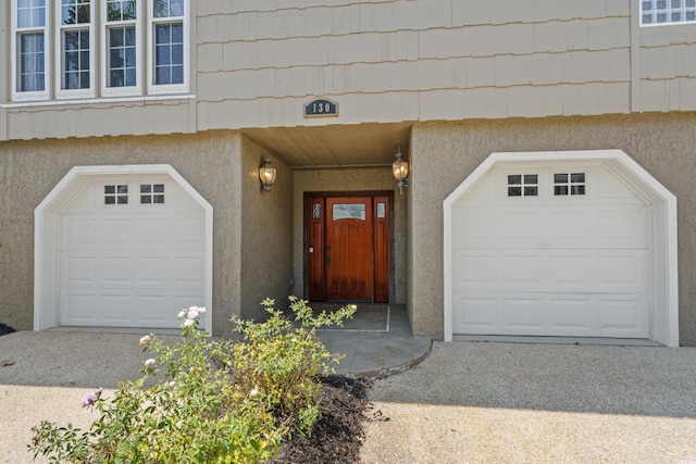 doorway to property with stucco siding and a garage