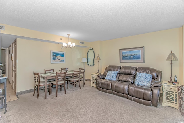 living room featuring visible vents, a textured ceiling, a chandelier, and carpet