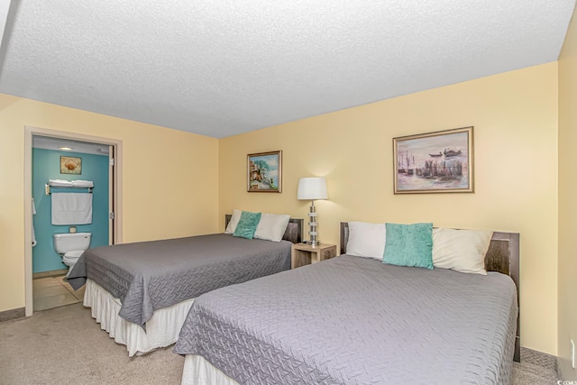 bedroom featuring carpet floors, ensuite bath, and a textured ceiling