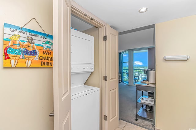 clothes washing area with laundry area, light tile patterned flooring, stacked washer / dryer, recessed lighting, and light colored carpet