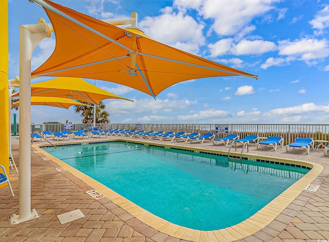 pool featuring fence and a patio area
