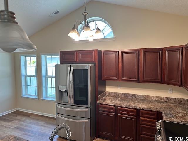 kitchen with visible vents, lofted ceiling, a chandelier, stainless steel appliances, and light wood-style flooring