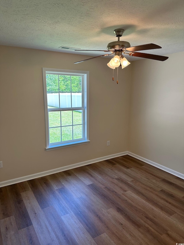 spare room featuring a textured ceiling and dark wood-style flooring