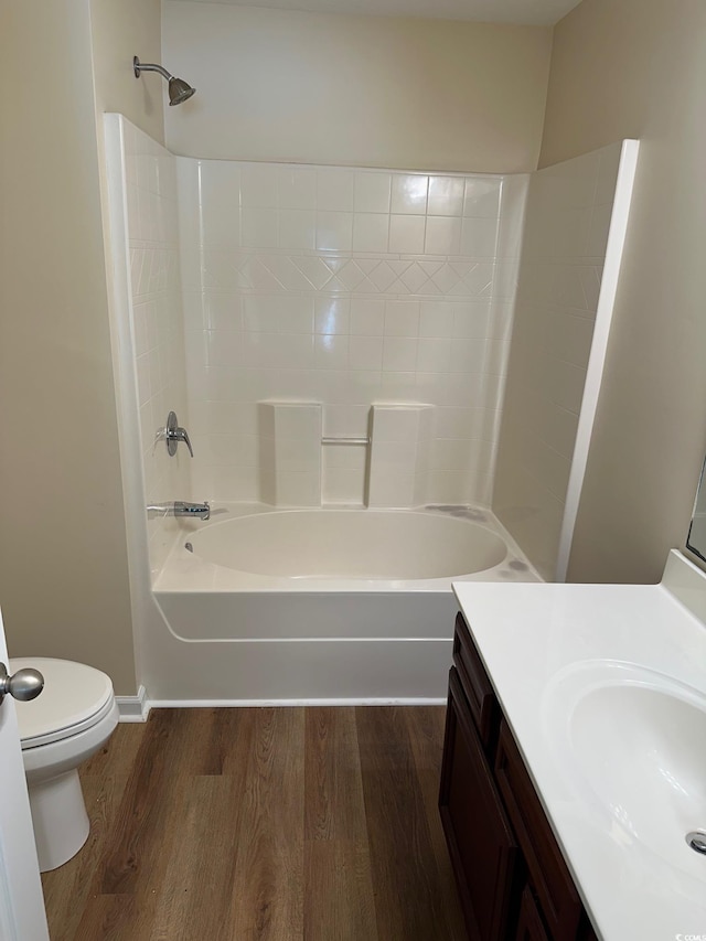 full bathroom with wood finished floors, vanity, baseboards, toilet, and tub / shower combination
