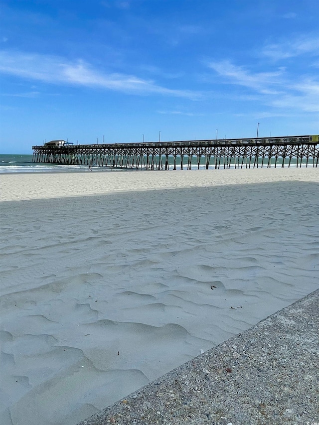 view of water feature with a view of the beach and a pier