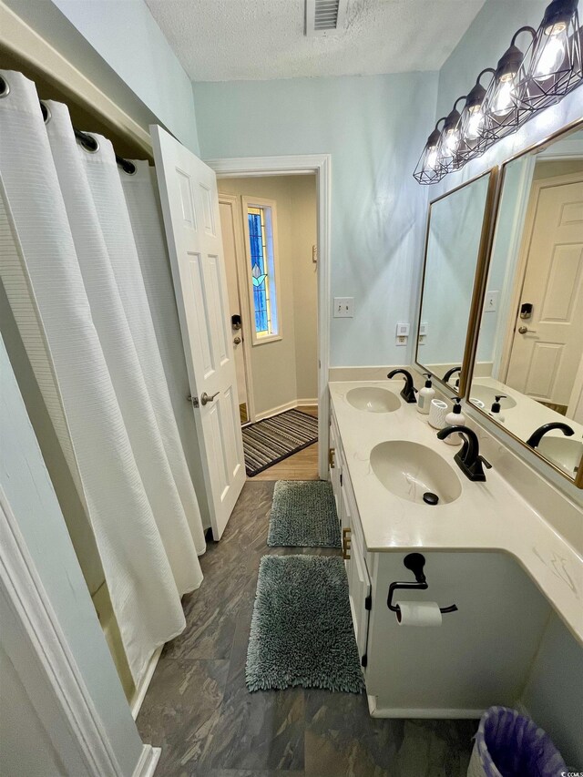 625 N Waccamaw Dr Unit 101, Murrells Inlet, SC 29576 - bathroom featuring a textured ceiling, double vanity, and a shower with curtain