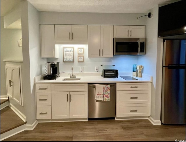 625 N Waccamaw Dr Unit 101, Murrells Inlet, SC 29576 - kitchen featuring appliances with stainless steel finishes, a sink, dark wood-style flooring, white cabinetry, and a textured ceiling