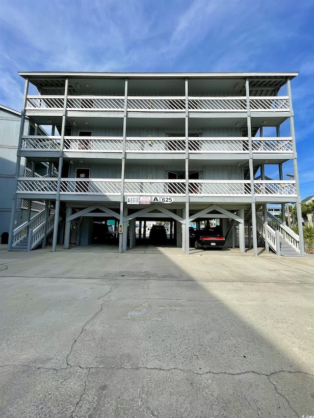 view of property featuring covered parking and stairway