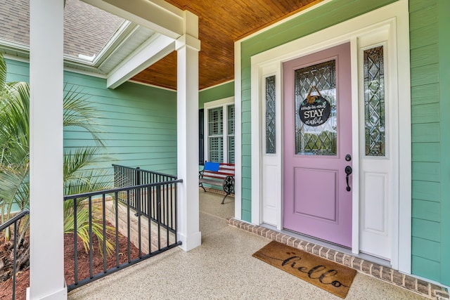 view of exterior entry featuring covered porch