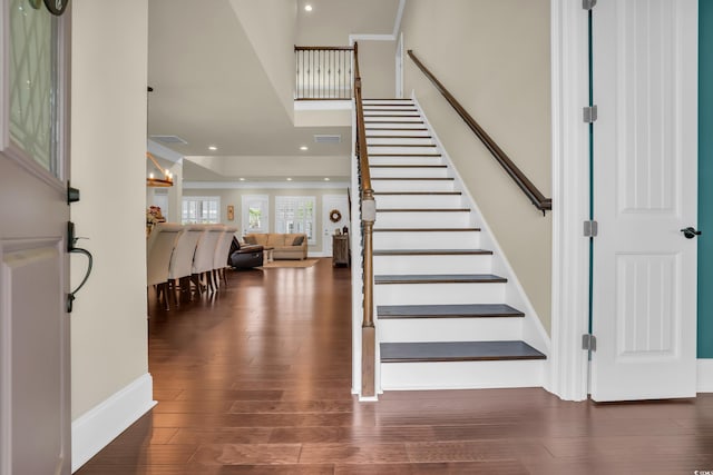foyer featuring baseboards, recessed lighting, wood finished floors, and stairway