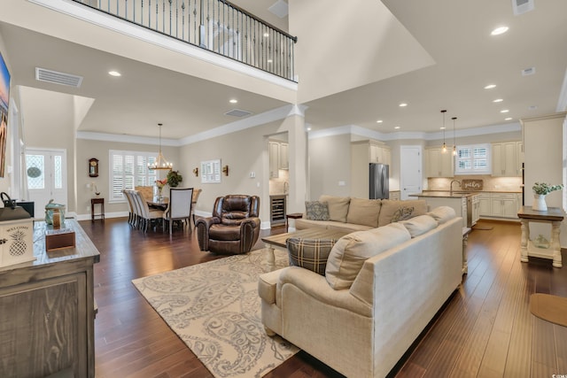 living area with crown molding, dark wood-type flooring, recessed lighting, and visible vents