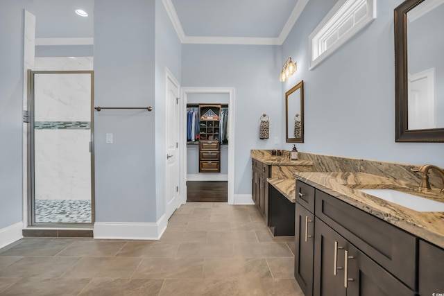 bathroom with vanity, ornamental molding, baseboards, a walk in closet, and a shower stall