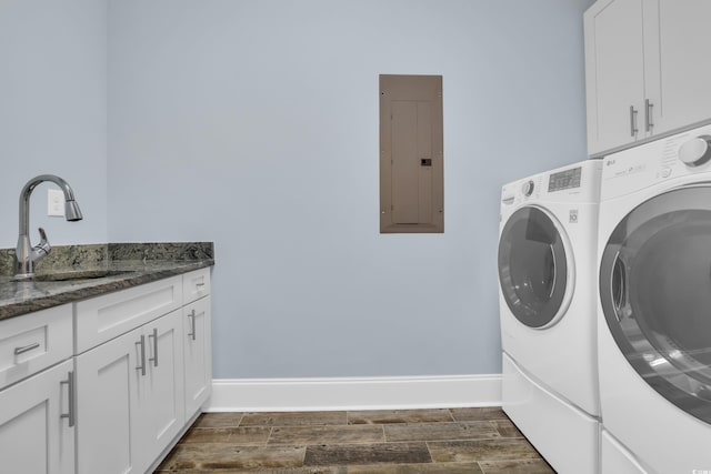 laundry room featuring dark wood-style flooring, washer and clothes dryer, electric panel, a sink, and cabinet space