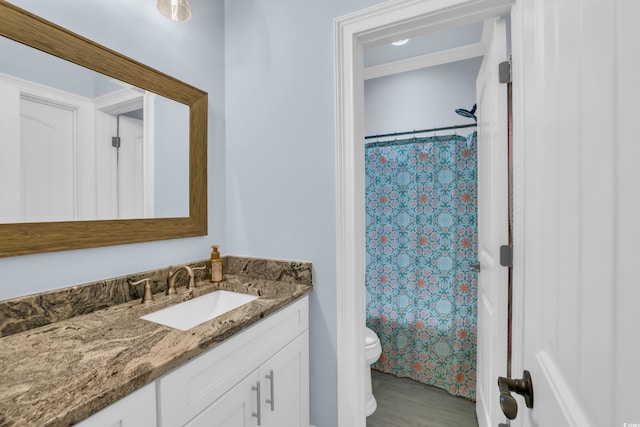 bathroom with vanity, toilet, wood finished floors, and a shower with shower curtain