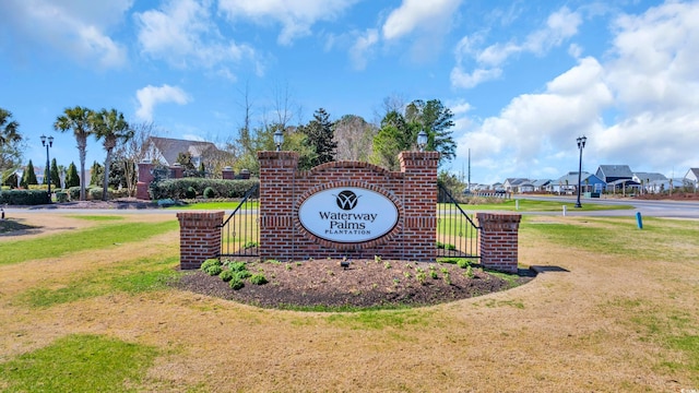 community sign featuring a lawn and a residential view