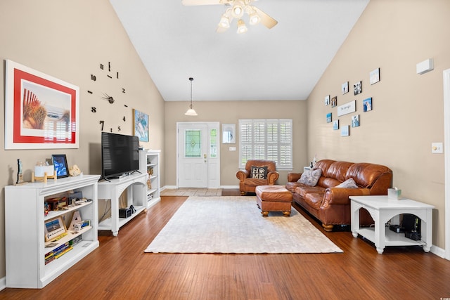 living area featuring high vaulted ceiling, ceiling fan, baseboards, and wood finished floors