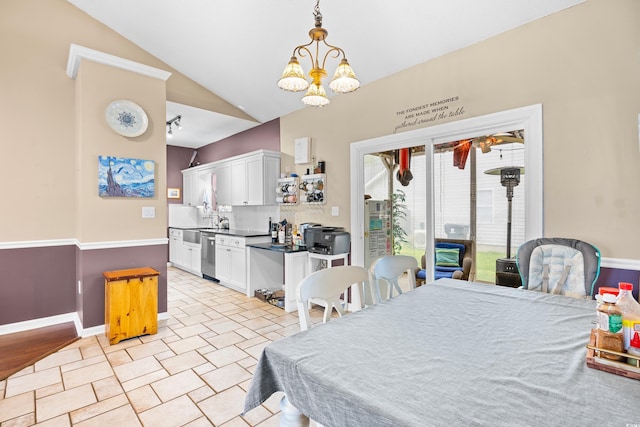 dining room featuring an inviting chandelier, baseboards, and lofted ceiling