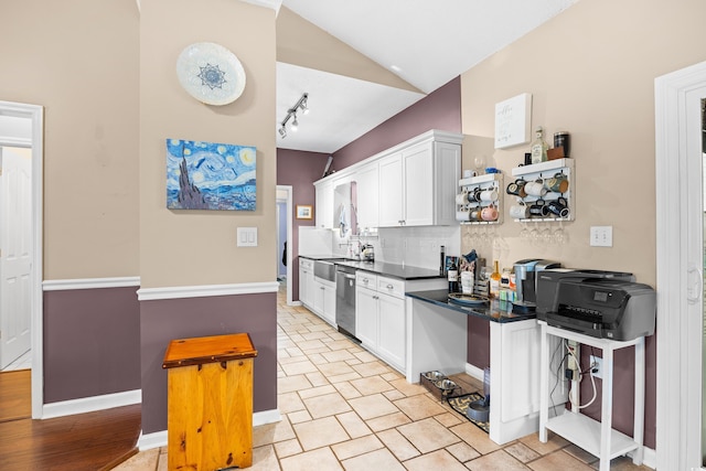 kitchen with backsplash, dark countertops, dishwasher, track lighting, and white cabinetry