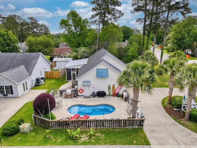 view of pool with a lawn, fence private yard, cooling unit, a fenced in pool, and a patio