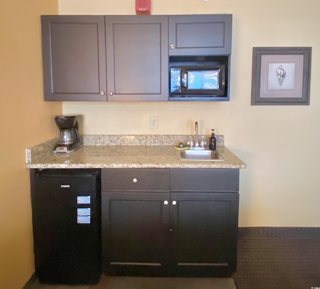 bar with indoor wet bar, a sink, and black microwave