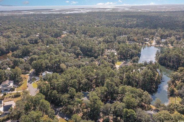birds eye view of property with a water view and a wooded view