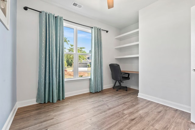 home office with visible vents, a ceiling fan, baseboards, and wood finished floors