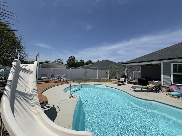 view of swimming pool featuring a fenced in pool, a fenced backyard, a ceiling fan, and a patio area