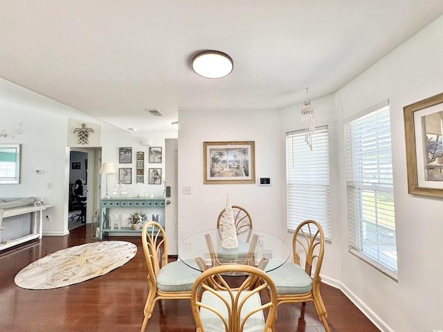 dining space featuring dark wood-style flooring, visible vents, and a wealth of natural light