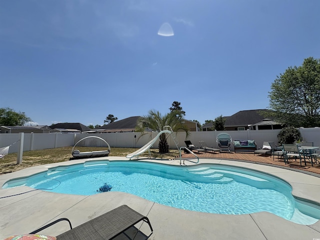 view of swimming pool featuring a fenced backyard, a fenced in pool, a water slide, and a patio area